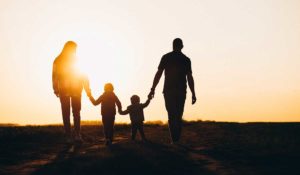 família caminhando em direção ao por do sol